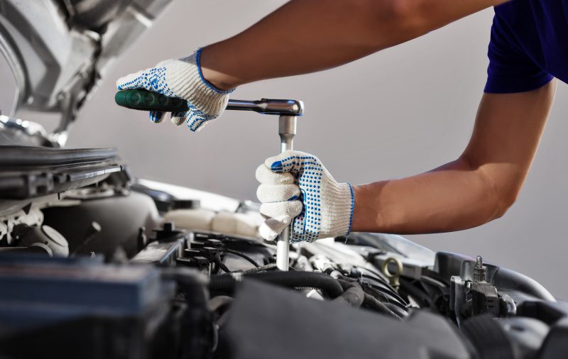 Two hands wearing gloves fixing car